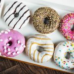 Ariel view of an open box of donuts.