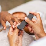 A nail technician filing a person's nails